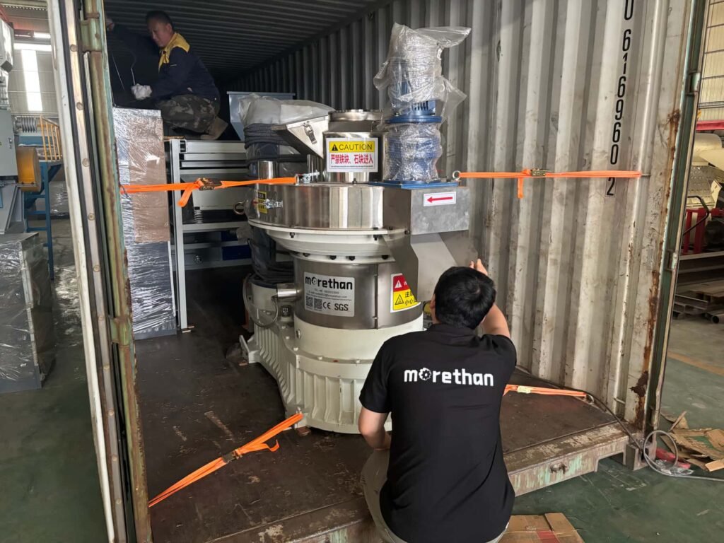 Worker securing vertical biomass pellet mill during container loading